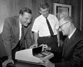 Shown here in 1967 are, (left to right) Barney Oliver, first director of HP Labs, Bill Hewlett, co-founder of HP and Arthur C. Clarke, the noted science-fiction author looking at the 9100 desktop calculator.